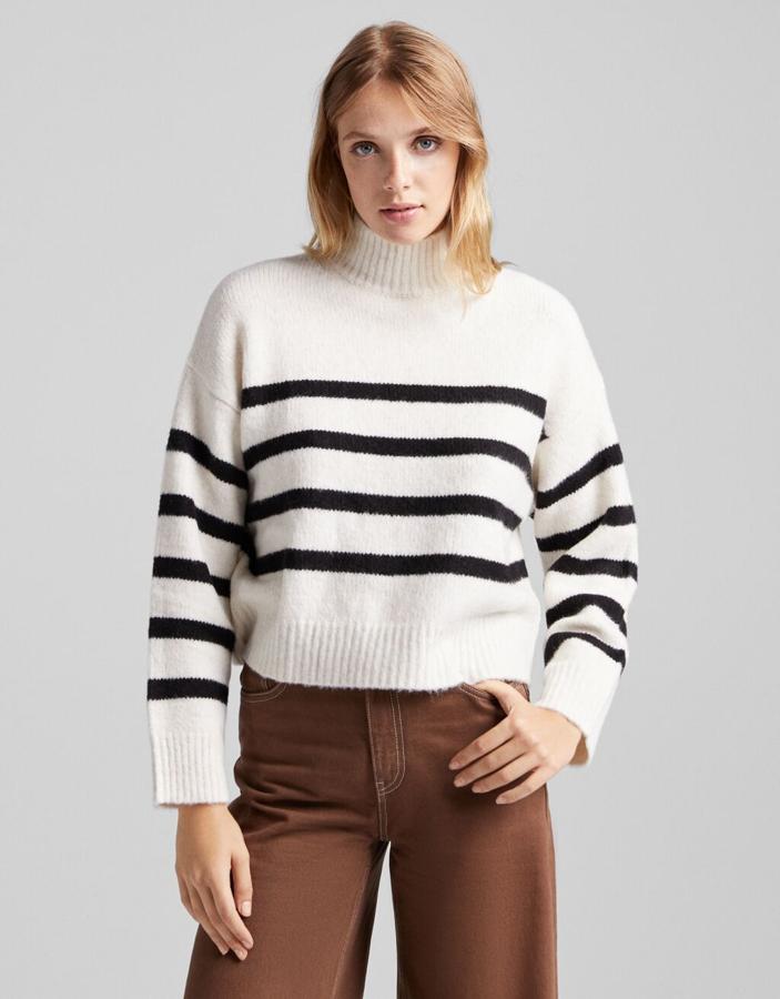 Disponible en color arena, gris o crudo con rayas negras horizontales, este jersey de cuello alto y tacto suave de Bershka tiene un precio de 19,99 euros y está disponible entre las tallas XS y XL. 