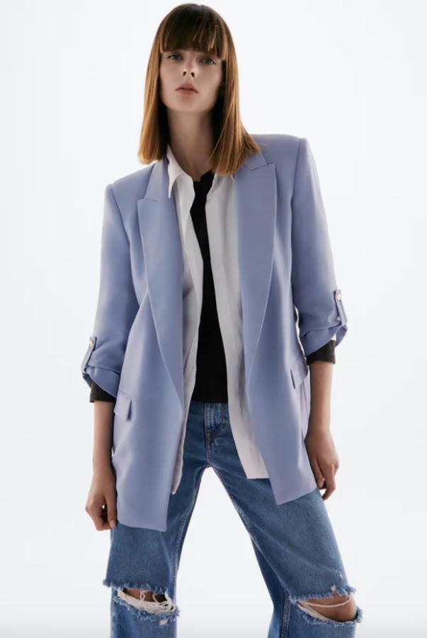 En Zara han lanzado esta bonita blazer con manga por debajo del codo acabada en vuelta con trabilla y botón en cinco colores: negro, fucsia, azul, crudo y verde. Con cuello con solapa con muesca y bolsillos laterales con solapa, cuesta 39,95 euros y está disponible entre las tallas XS y XXL. 