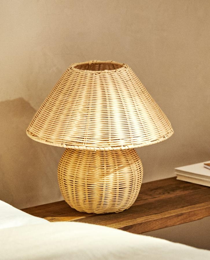 Lámpara de mesa fabricada en ratán con trenzado de color natural, ideal para el dormitorio. Cuesta 39,99 euros.