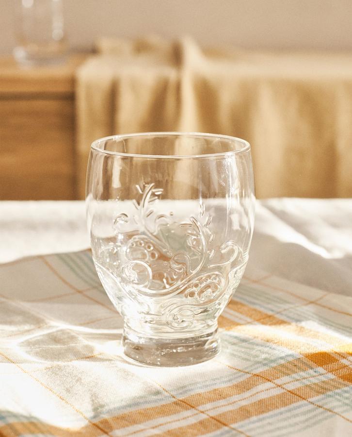 Con diseño floral en relieve, este vaso transparente en vidrio de Zara Home es lo que necesitas para tu casa de campo. Cada vaso cuesta 1,99 euros.