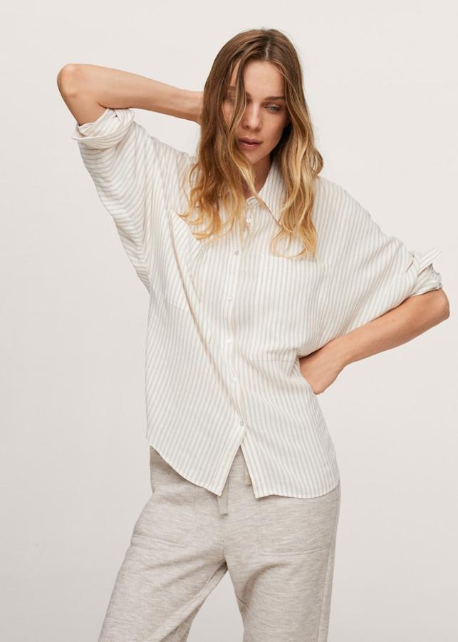 Diseño oversize para esta camisa con estampado de rayas en beige sobre color blanco de Mango confeccionada en tejido de mezcla de lino con textura y cuello clásico. Tiene las mangas largas con los puños abotonados, costura del hombro caída y dos bolsillos de plastrón en la pechera. Con cierre de botones frontal en efecto nácar, podemos encontrarla entre las tallas XS y XL por 29,99 euros.