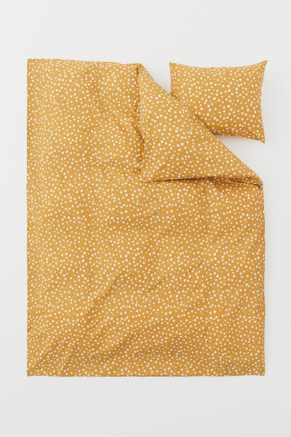 Con una medida de 150x200 centímetros, esta funda nórdica de color amarillo con topos blancos está confeccionada en algodón orgánico de hilo fino y tiene un precio de 19,99 euros.