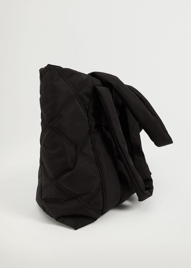En color negro, este bolso shopper de Mango de diseño acolchado viene con dos asas largas, bolsillo interior con cremallera y forro interior. Tiene cierre superior de cremallera y un precio de 29,99 euros.
