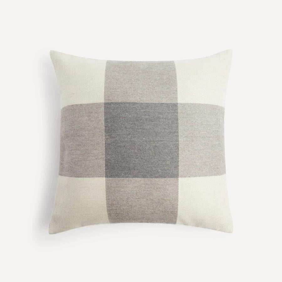 Los cuadros cobran protagonismo en otoño. Si quieres optar por este estampado de forma sutil, una buena opción es este cojín (19,95 euros) de El Corte Inglés. 