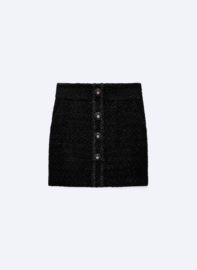 Falda corta en negro con botones fantasía de Uterqüe. 79 euros