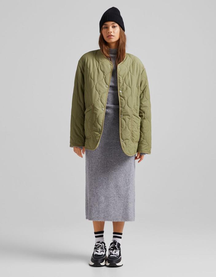 En efecto nylon, y disponible en verde caqui o en negro, esta cazadora con bolsillos de plastrón laterales, cuello redondo y cierre frontal de snaps es de Bershka y podemos encontrarla entre las tallas XS y L por 29,99 euros.