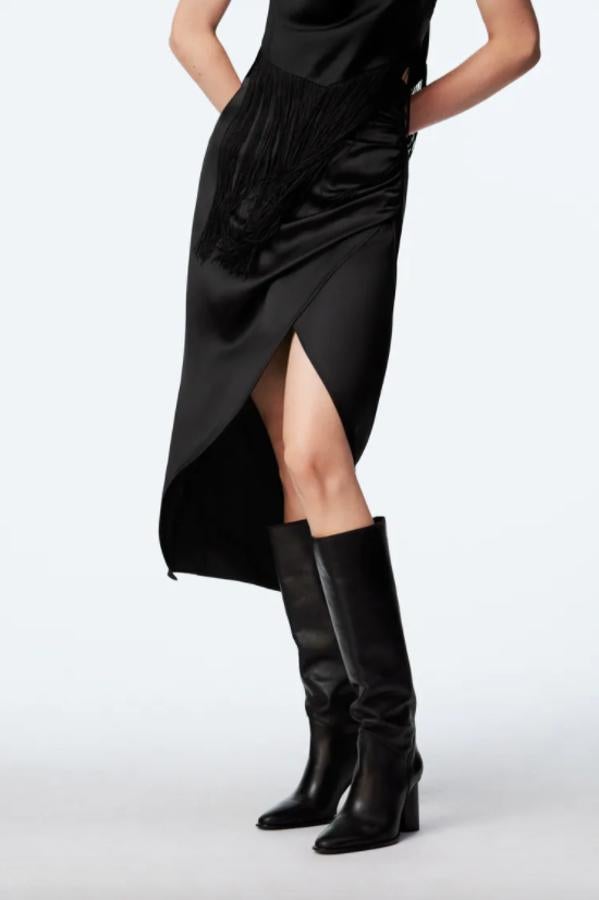 De tiro alto con frunces laterales, esta falda negra satinada de Zara con bajo con abertura cuesta 29,95 euros y está disponible entre las tallas XS y XL. 