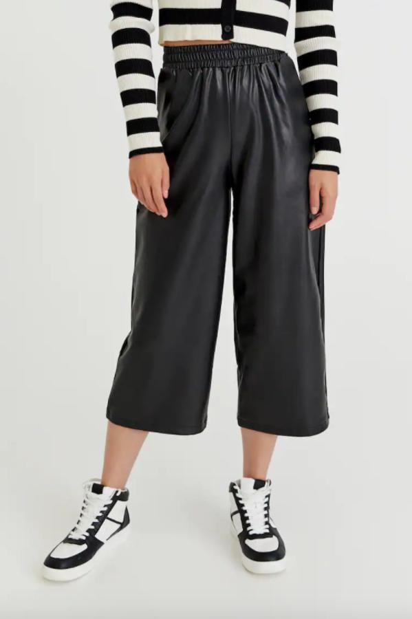 En Pull&Bear han apostado por el favorecedor diseño culotte para estos pantalones negros en efecto piel que vienen con dos bolsillos laterales y cintura elástica con trabillas. Disponibles entre las tallas XS y XL, cuestan 22,99 euros. 
