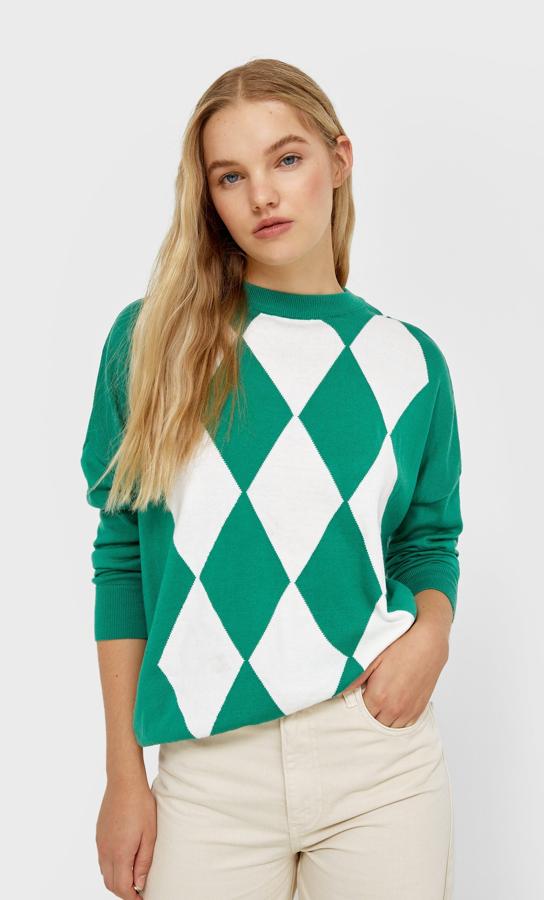 En color verde con estampado de rombos en blanco, este jersey de diseño ligeramente amplio y mangas largas de es de Stradivarius y tiene cuello redondo y terminaciones en rib. Disponible entre las tallas XS y XL, cuesta 25,99 euros. 