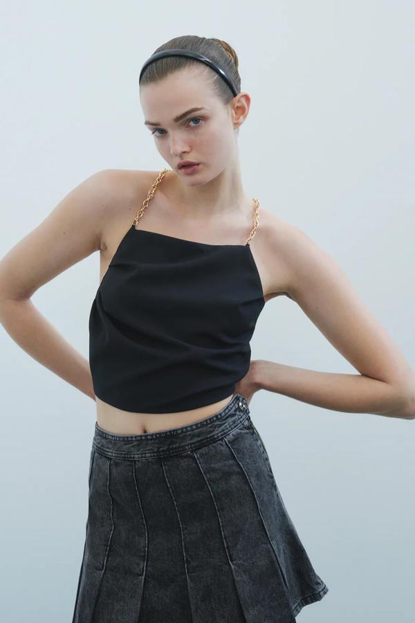 En tejido denim de color negro, esta falda mini plisada con cierre lateral tiene un precio de 22,95 euros. Es de Zara.