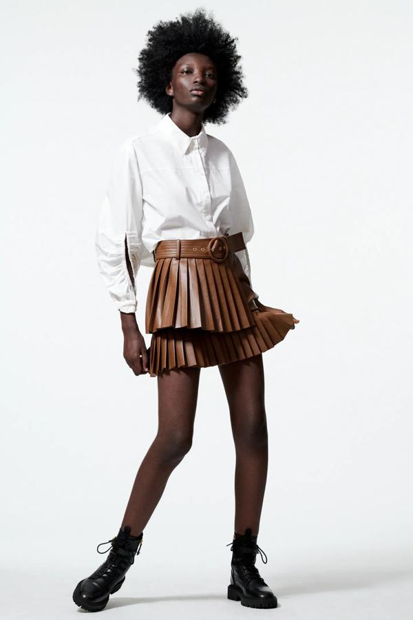En color tostado, esta falda mini plisada en tejido de efecto piel y tiro alto cuenta con cinturón a juego y cierre lateral con cremallera oculta. Es de Zara y tiene un precio de 25,95 euros.