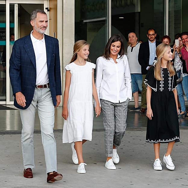 Imagen principal - La Reina Letizia, amante de los looks comfy con zapatillas de Hugo Boss.