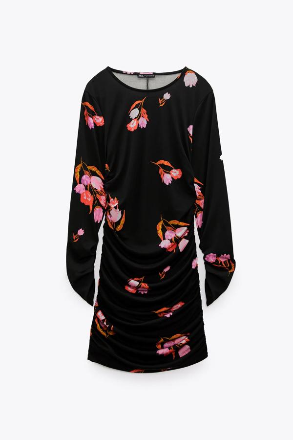 Este vestido drapeado en color negro con estampado de flores y manga larga cuenta con pliegues en los laterales y tiene un precio de 22,95 euros. Es de Zara. 