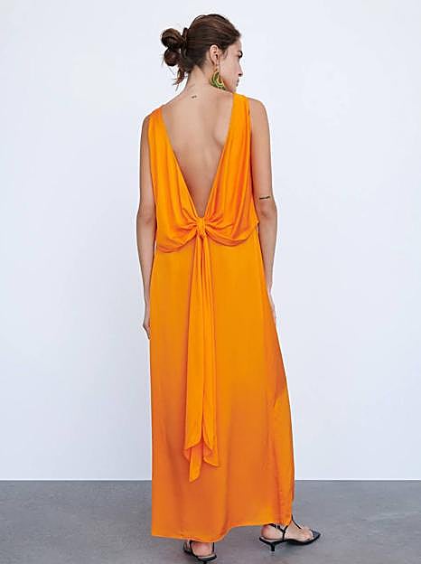 Vestido largo fluido con espalda al aire en naranja, de Zara. 49,95 euros