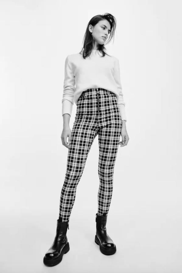 De tiro alto, con cintura elástica y cierre frontal con cremallera metálica, estos leggings de Zara con estampado de cuadros blancos y negros cuestan 19,95 euros y está disponible entre las tallas XS y XXL.