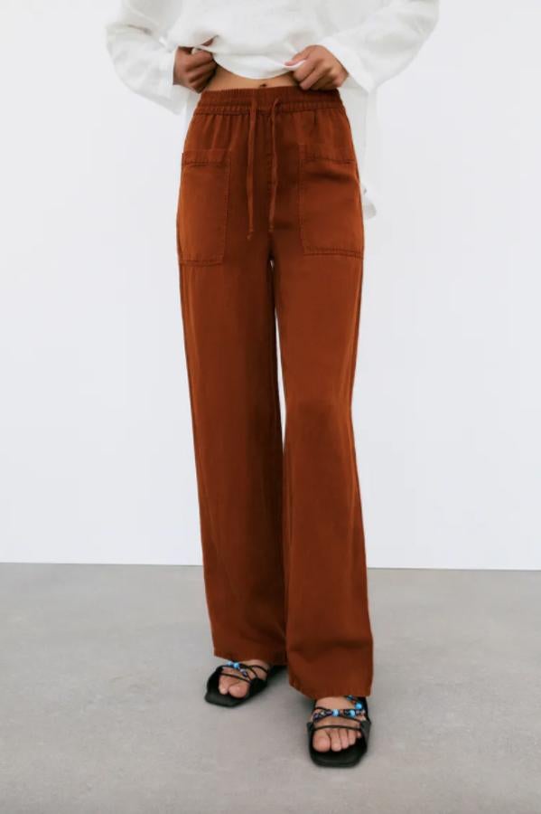 En tono teja y diseño relajado estos jogger de pernera ancha de Zara con cintura elástica ajustable con cordones y tiro alto viene con bolsillos de plastrón en delantero y espalda. Cuesta 29,95 euros y está disponible en las tallas XS, S y M