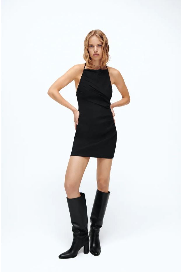 Este mini vestido de lino negro con efecto drapeado, también disponible en verde oliva, cuesta 15.99 euros en los Special Prices de Zara.