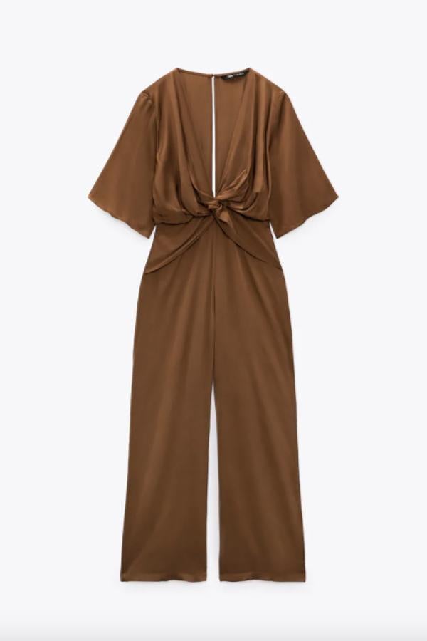 En color chocolate, con escote de pico con nudo y mangas cortas amplias hasta el codo, este mono de Zara de perneras anchas y detalle de abertura en espalda cuesta 39,95 euros y está disponible entre las tallas XS y L.
