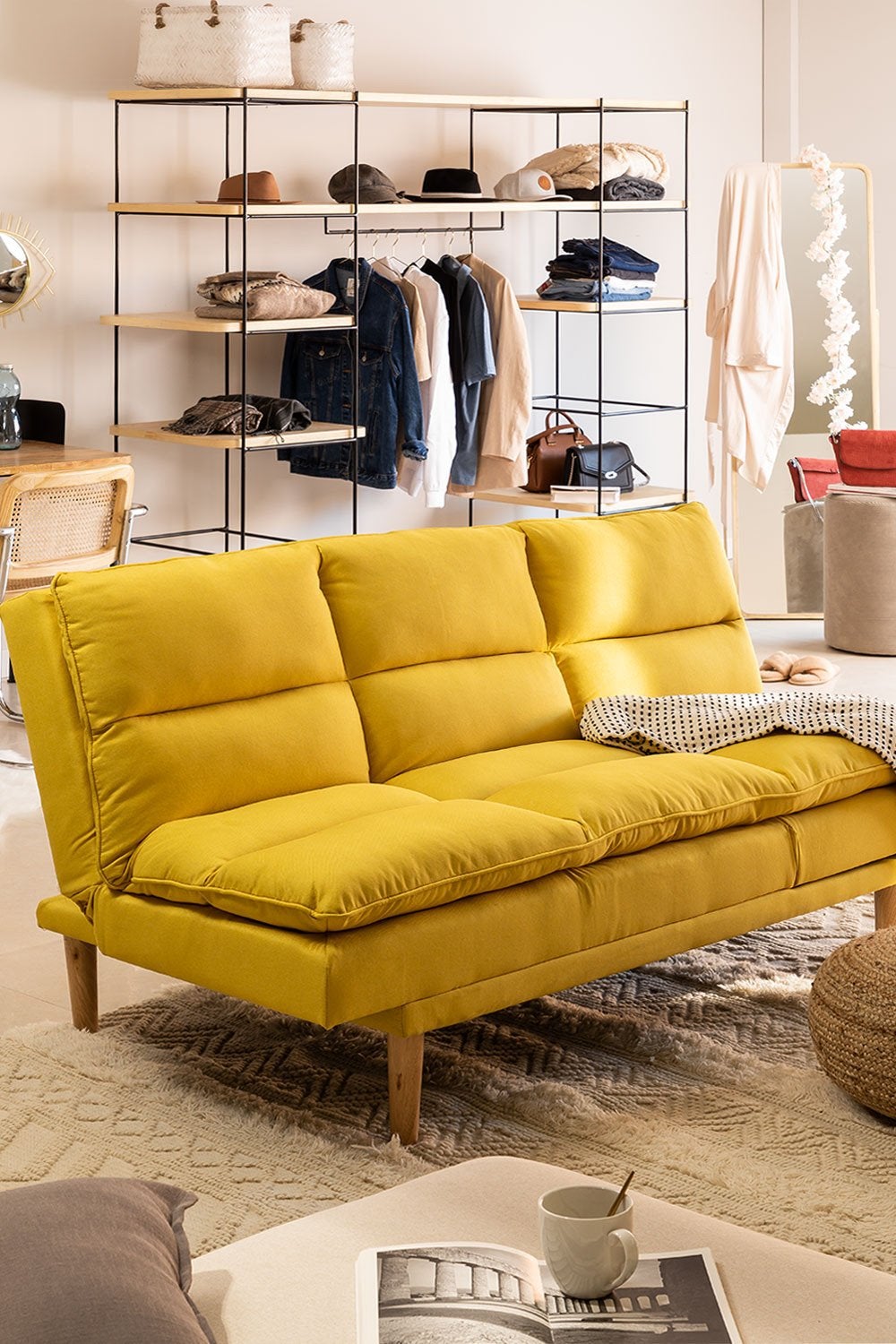Práctico, cómodo y súper decorativo, este sofá cama en lino amarillo de Sklum pondrá la nota más especial en tu salón o en uno de los dormitorios de tu casa. Precio: 299.95 euros.
