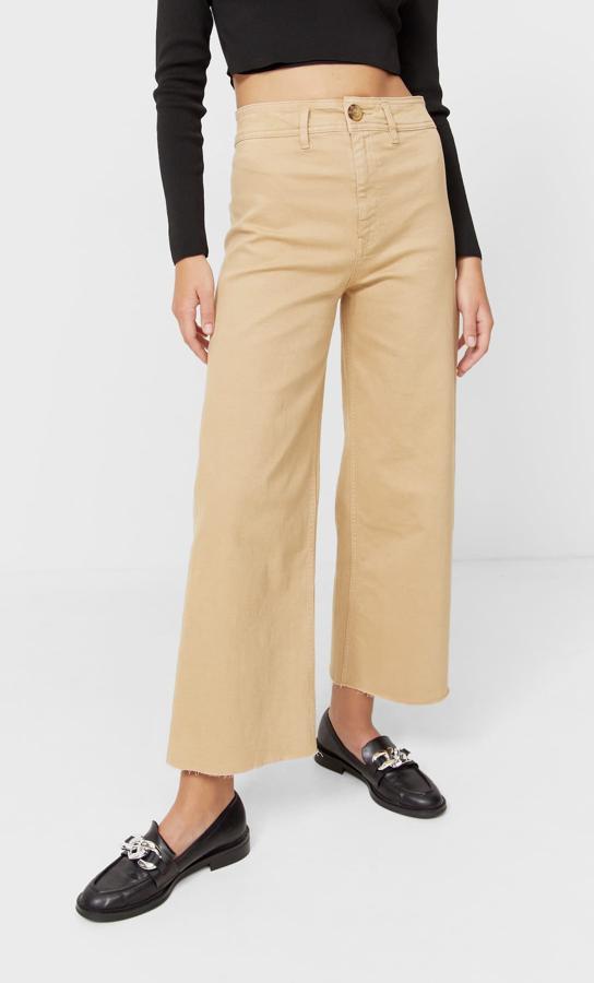 Disponible en ocho colores diferentes, entre ellos el negro, el beige o el caqui, este pantalón culotte de tiro alto con perneras anchas y bajos deshilachados es de Stradivarius, tiene un precio de 25,99 euros y está disponible entre las tallas 32 y 44. 