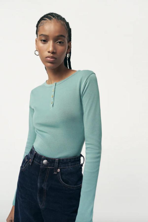 Con mangas largas, cuello redondo y cierre frontal de botones a contraste en el escote, esta camiseta disponible en negro, blanco, azul y beige tiene un precio de 9,95 euros y está disponible en las tallas S, M y L. 