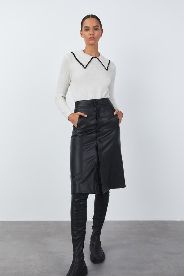 Cuello baby doll con ribete a contraste en negro para este jersey blanco que viene con mangas largas está disponible en las tallas S, M y L por un precio de 19,99 euros. 