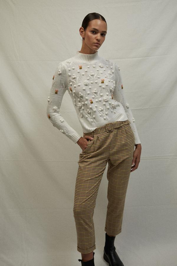 Con detalle de madroños en marrón y rosa, este jersey blanco con cuello perkins y bordados en el cuerpo y las mangas largas está disponible en las tallas S, M y L por 29,99 euros. 