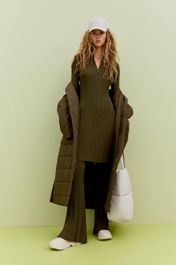 Cuello alto y cierre de cremallera bidireccional en el frontal para este vestido de canalé de H&M con mangas extralargas ceñidas con abertura para el pulgar y largo por encima la rodilla. Tiene un precio de 49,99 euros y está disponible entre las tallas XS y XXL.