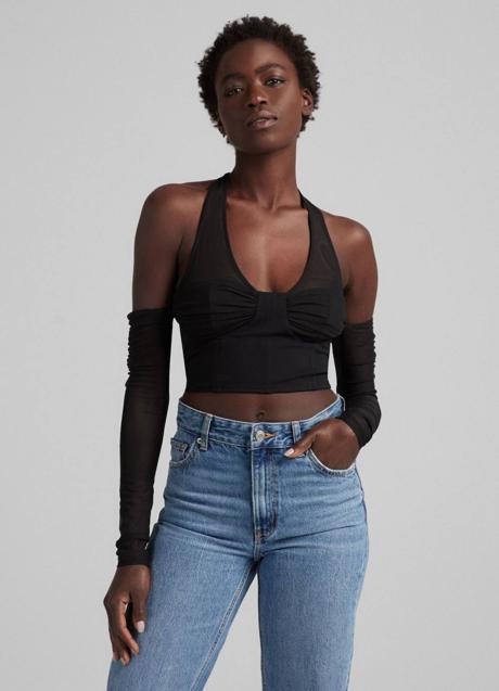 Imagen - La camiseta con los hombrs descubiertos tieen un cierre de lazada al cuello