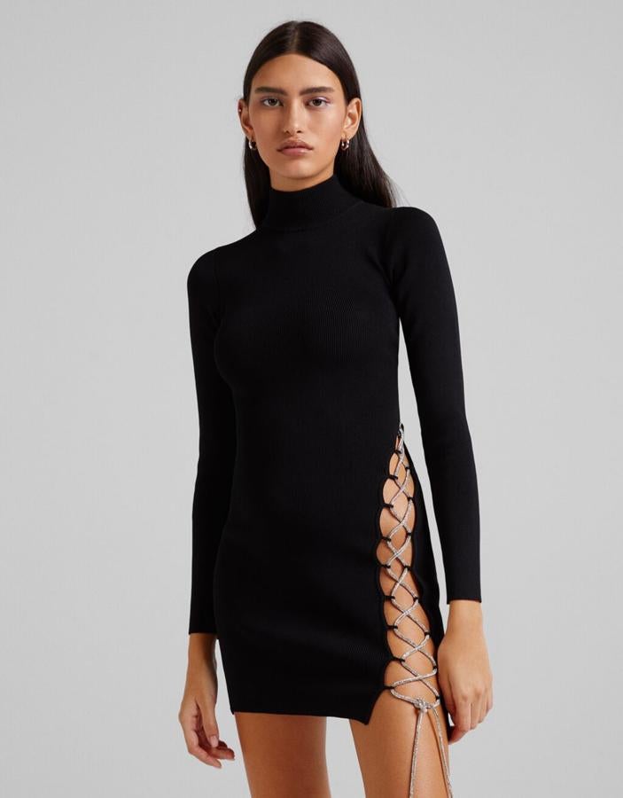 Cuello alto y diseño mini para este vestido negro de Bershka con detalle lace up de strass en un lateral que cuesta 35,99 euros y está disponible entre las tallas XS y L.