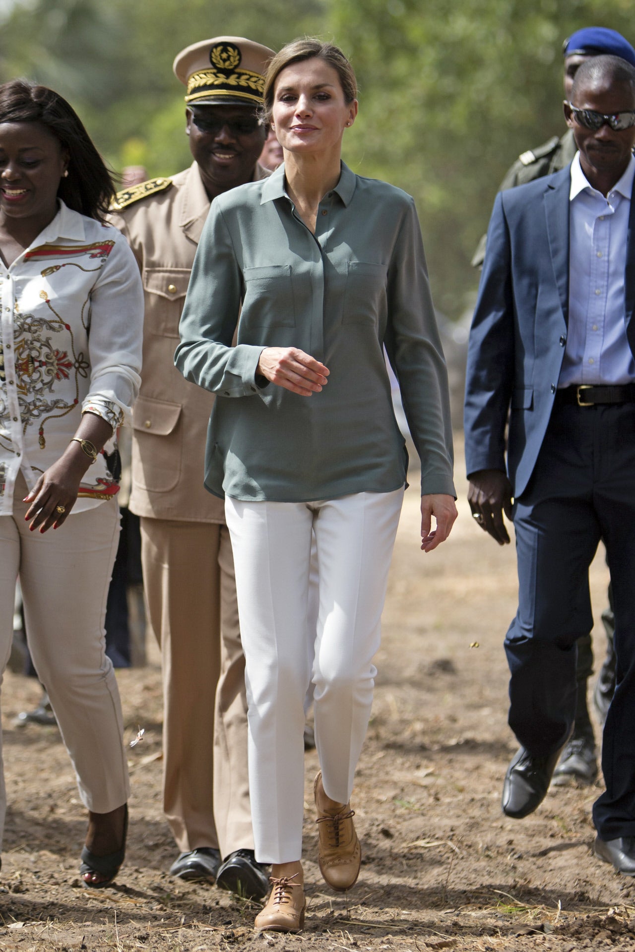 Una de los primeros looks 'de campo' de la Reina durante un viaje de cooperación fue este en Senegal, con blusa tipo sahariana, pantalones blancos y zapatos planos cómodos.