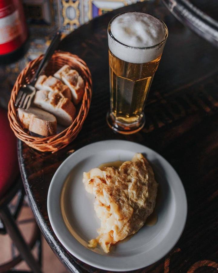 La tortilla de patata debería ser Patrimonio de la Humanidad, pero mientras nos ponemos de acuerdo sobre si su receta debe ir con cebolla o sin cebolla, te recomendamos que vayas a probar, acompañada de un buen vermú, la que sirven en Bodega de la Ardosa (calle Colón, 13).