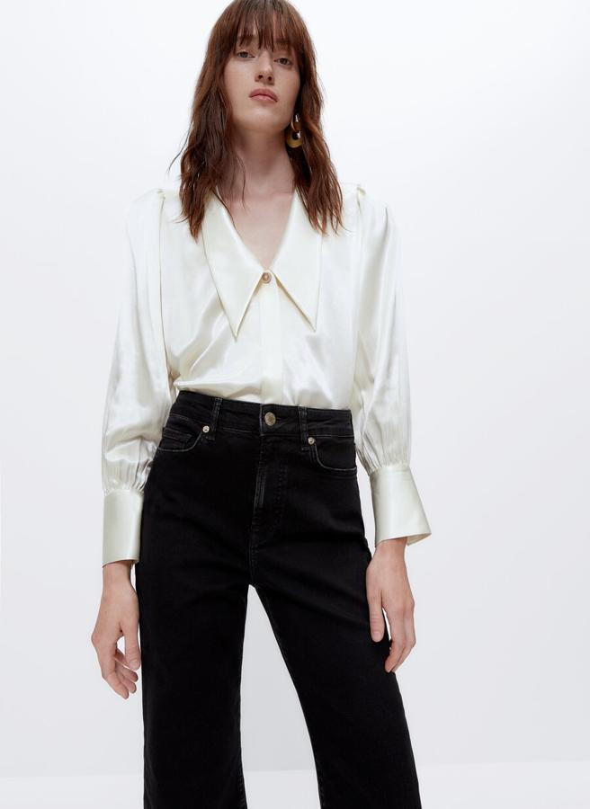 Escote de pico y cuello de solapa puntiaguda para esta camisa satinada de Uterqüe en color crudo con cierre de botón joya en la parte superior y el resto ocultos por tapeta. Solo queda en las tallas M y L y cuesta 79 euros.