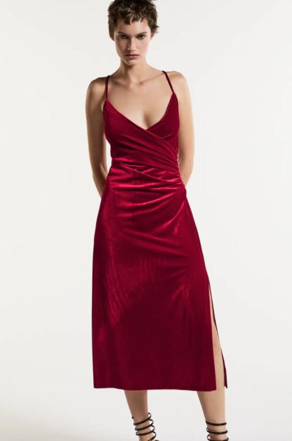 Diseño midi y color rojo para este vestido de terciopelo de Zara con escote de pico cruzado y detalle de pliegues laterales. Con bajo acabado en abertura, podemos encontrarlo entre las tallas XS y XXL por 29,95 euros. 