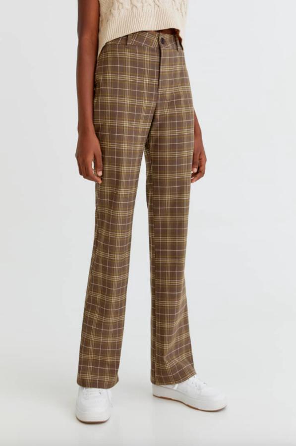 Marrón, lima y blanco para este pantalón de cuadros de Pull&Bear que tiene perneras ligeramente acampanadas y cuesta 22,99 euros. Está disponible entre las tallas XS y XL.