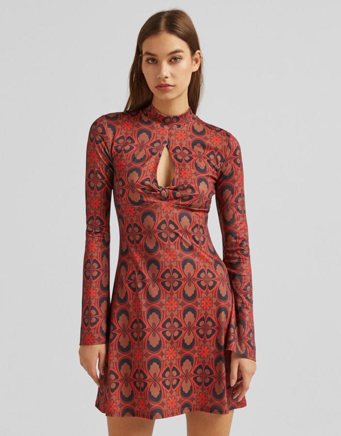 En tonos rojos con estampado en negro y anaranjado, este vestido mini de Bershka con cuello alto y abertura en el escote tiene un precio de 22,99 euros y está disponible entre las tallas XS y L. 