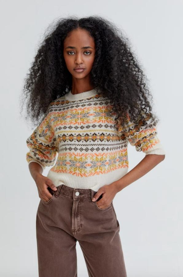 Estampado en tonos anaranjados y marrones para este jersey en punto jaquard y color arena de Pull&Bear de mangas largas y cuello redondo. Tiene un precio de 29,99 euros y está disponible entre las tallas XS y L. 