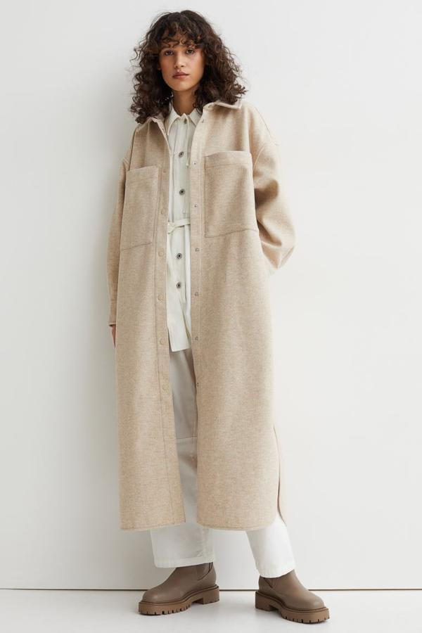 En beige claro jaspeado, con bolsillos de plastrón XL en la pechera y cierre de botones a presión en el frontal, esta sobrecamisa larga de H&M que queda por debajo de la rodilla es de diseño de hombros caídos y cuesta 49,99 euros. 