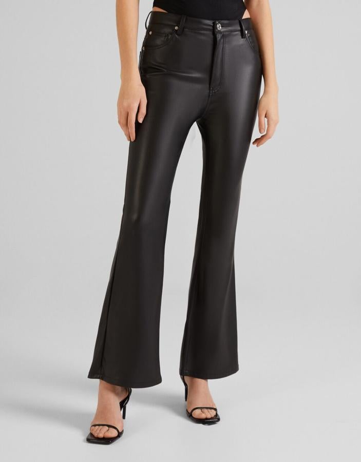 Diseño flare y color negro para estos pantalones de Bershka con bajos acampanados, bolsillos laterales y traseros y cierre frontal de botón a tono que cuestan 22,99 euros y podemos encontrar entre las tallas XS y XL. 