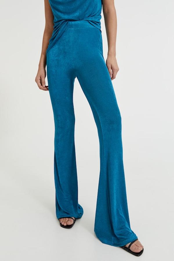 Disponibles en azul pato o en color púrpura, estos pantalones de bajos acampanados con cintura elástica confeccionados en tejido fluido son de Pull&Bear y tienen un precio de 19,99 euros. En la web están agotados los dos diseños en todas las tallas.
