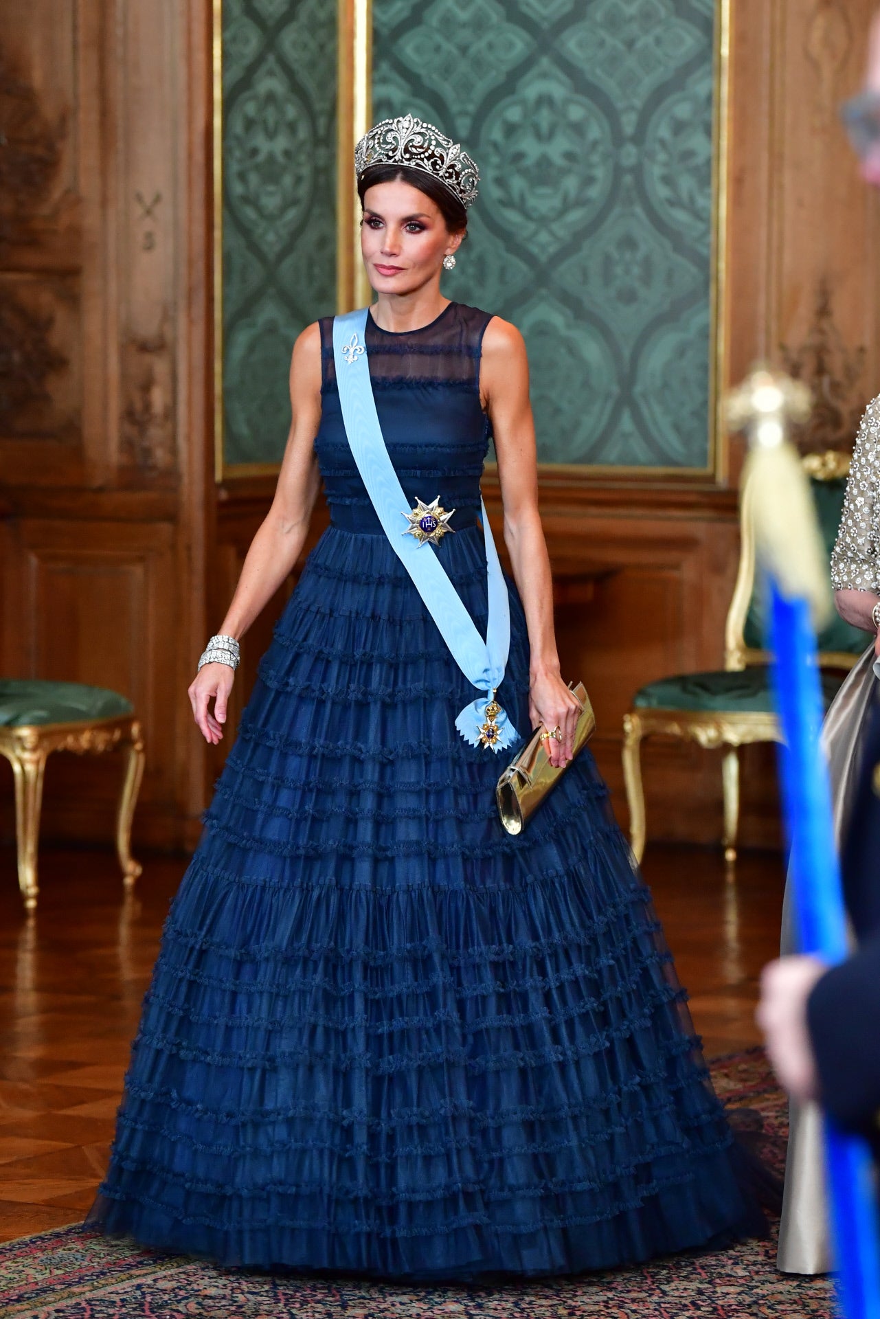 Era el momento más esperado del viaje a Suecia y doña Letizia no defraudó. La Reina apareció imponente en la cena ofrecida por los Reyes Carlos Gustavo y Silvia con un vestido de gala azul noche que le sentaba como un guante, un diseño sostenible de la colección Concious de H&M (el gigante sueco del low cost), haciendo así un guiño a sus anfitriones y eligiendo un modelo muy similar al de la Princesa Victoria de Suecia en la celebración de su décimo aniversario de boda. Como joyas, la impresionante tiara flor de lis, las pulseras gemelas de Cartier y los pendientes de chatones.