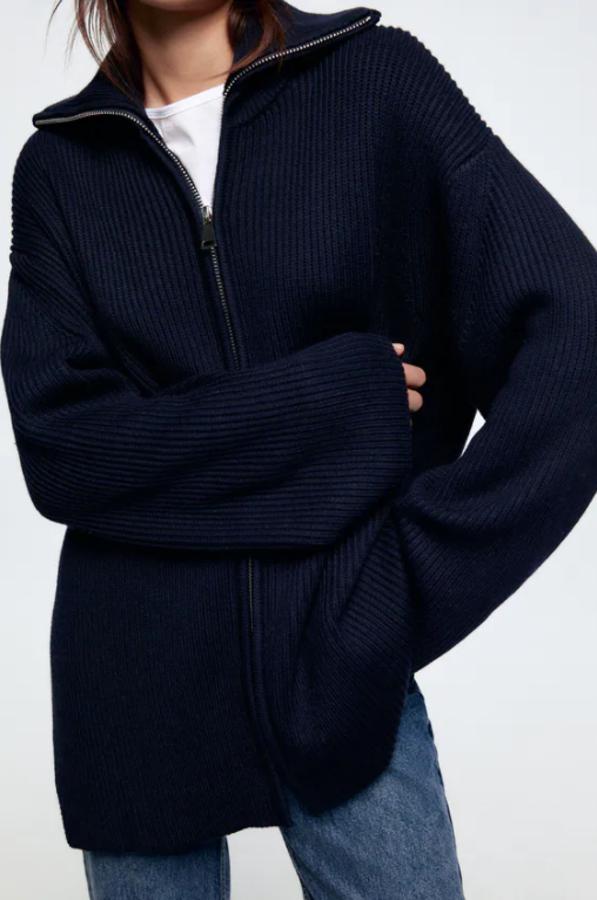 En azul marino, con cuello de solapa y mangas largas, este cárdigan de punto con cierre frontal de cremallera metálica es de Zara y cuesta 39,95 euros. 