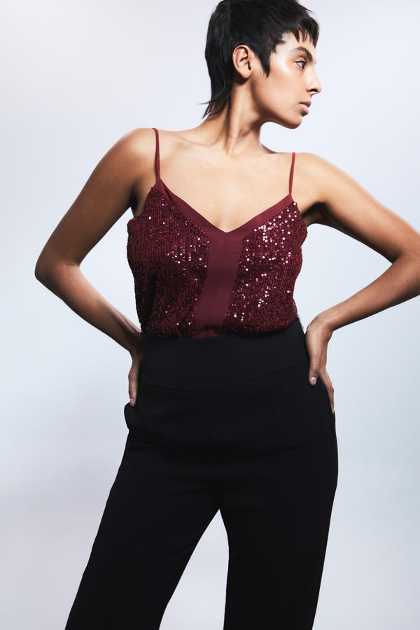 Disponible en arena, granate y negro, este top con escote de pico, tirantes finos y detalle de aplicación de lentejuelas a tono en el frontal es de Sfera y cuesta 15,99 euros.