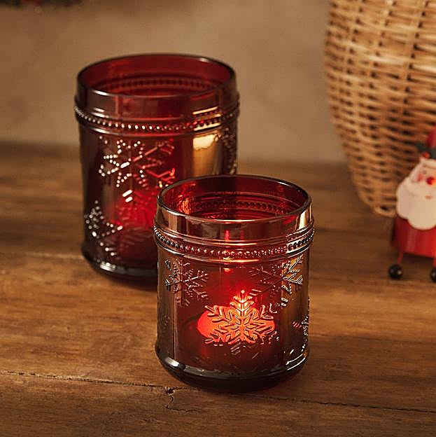 Imagen principal - El portavelas de cristal rojo con motivos navideños cuesta 5.99 euros; el portavelas con forma de hoja cuesta 12.99 euros y el dorado, 17.99 euros.