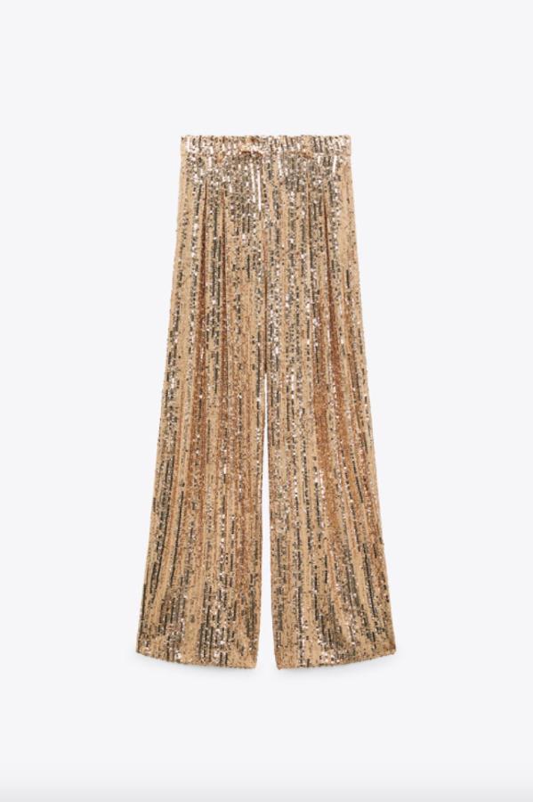 Tiro alto y perneras anchas para estos pantalones de lentejuelas de Zara en color dorado con detalle de pliegues en delantero que tienen un precio de 39,95 euros. 