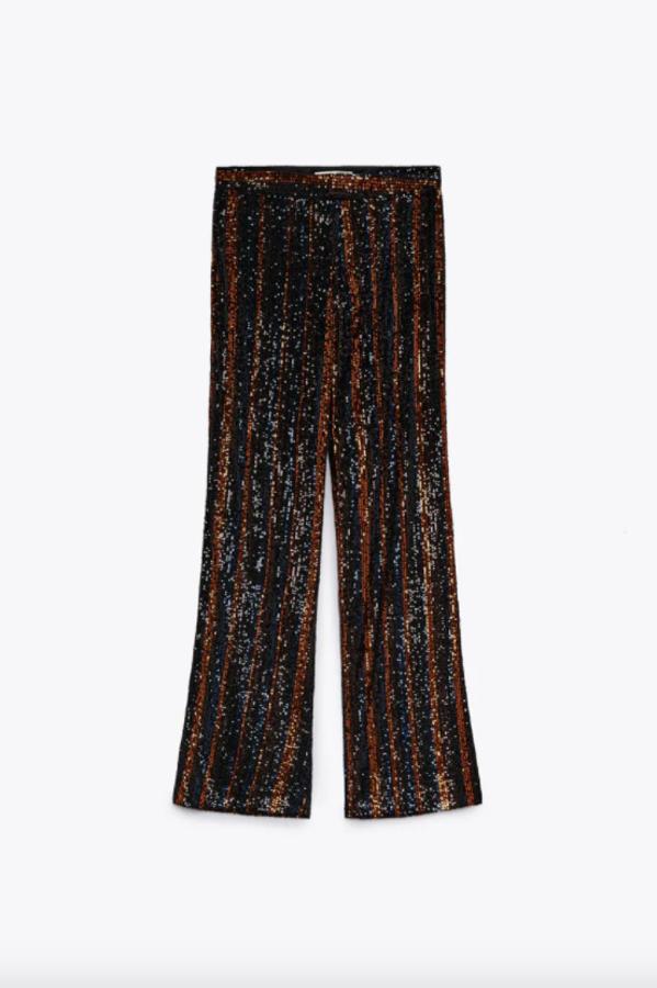 Diseño de rayas en tonos negros, marrones y azulados para este pantalón de lentejuelas de Zara que tiene el tiro alto y el bajo acabado en línea evasé. Cuesta 39,95 euros. 