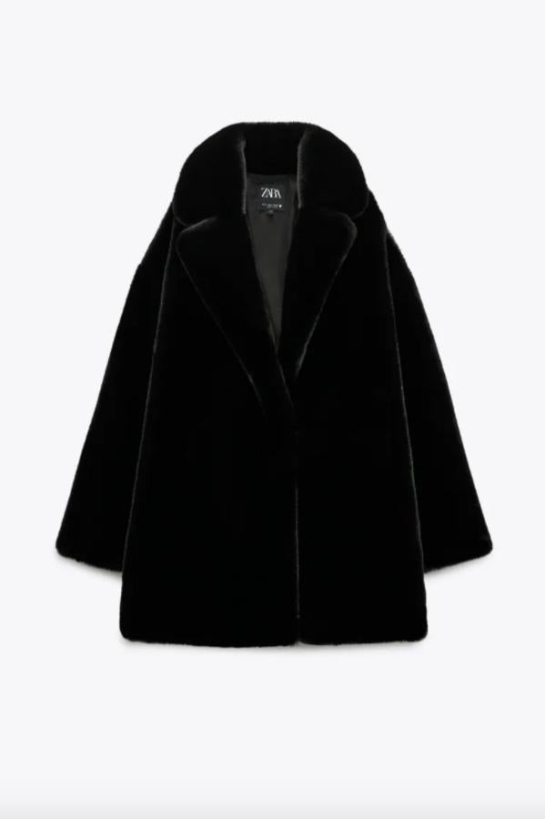 En efecto pelo, con cuello de solapa y mangas largas, este abrigo negro de Zara viene con bolsillos laterales ocultos en costura y cierre frontal con gancho metálico. Podemos comprarlo por 59,95 euros.