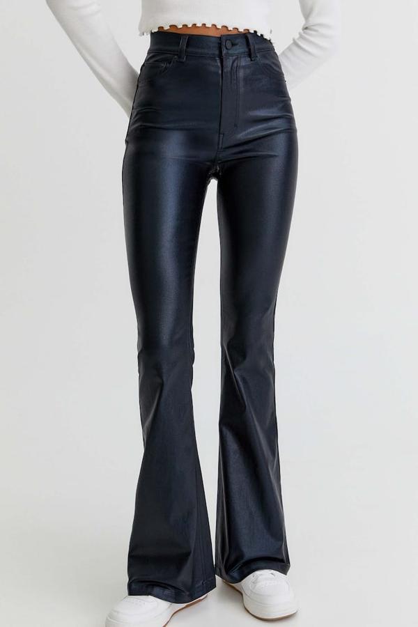 En tejido coated en color negro, estos pantalones de Pull&Bear con diseño acampanado, bolsillos laterales y cierre de botón y cremallera tienen un precio de 22,99 euros. 