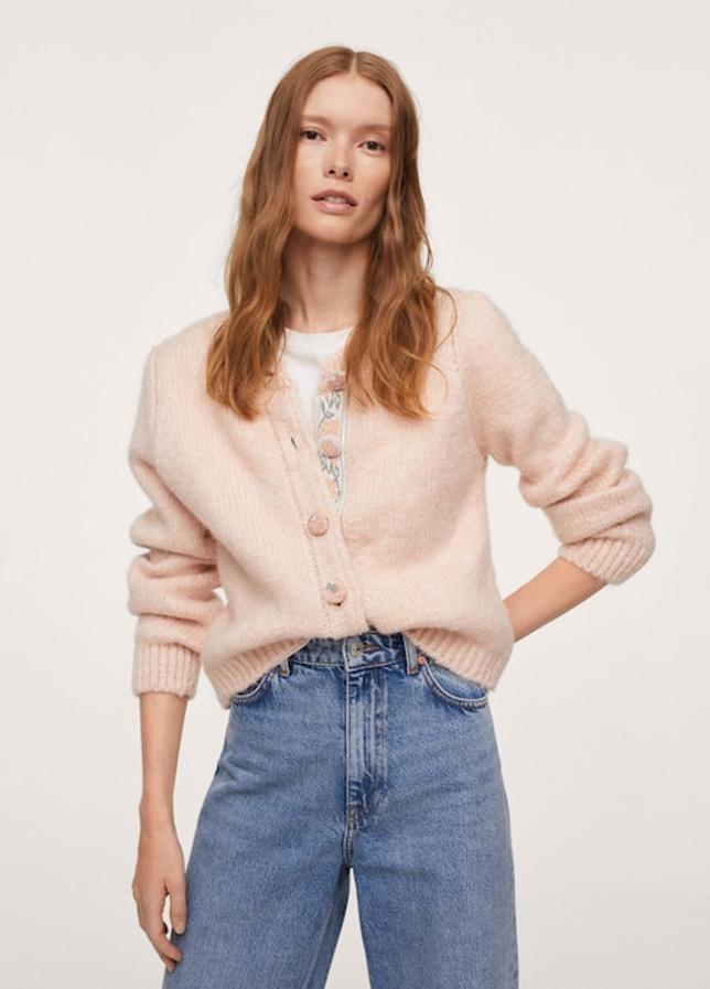 Confeccionado en punto grueso, de diseño cropped recto y cuello redondo, este cárdigan disponible en rosa pastel o en azul con cierre de botones frontal con botones forrados en estampado a tono ha pasado de costar 39,99 euros a 35,99 euros. 