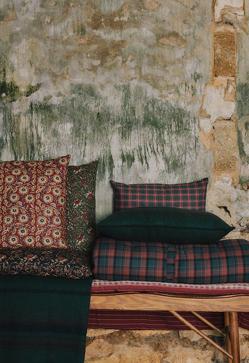 Imagen secundaria 2 - Las fundas de cojines de Zara Home cuestan entre 17.99 y 29.99 euros, las mantas entre 39.99 y 99.99 euros, las cestas, entre 5.99 y 39.99 euros. El banco de madera cuesta 249 euros y el topper estampado, 69.99 euros. El mantel de lino estampado con guirnaldas cuesta 59.99 euros.